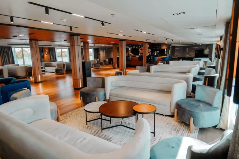 Lounge with white sofas and round coffee tables on MS Miriam