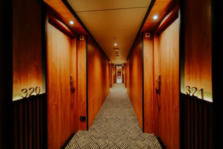 Wood-panelled cabin corridor with numbered doors on MS Miriam