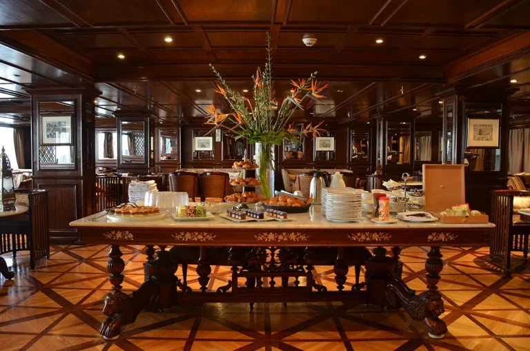 Breakfast table with pastries and flowers in wood-panelled restaurant