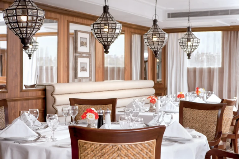 Restaurant tables beneath lantern-style pendant lights