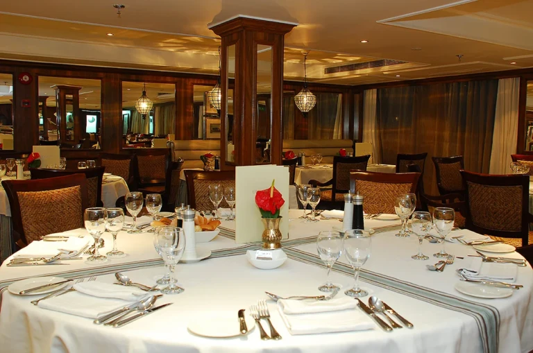 Restaurant round table set with glasses and a red flower