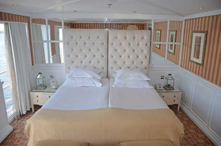 Double bed with tall tufted headboard and twin lamps