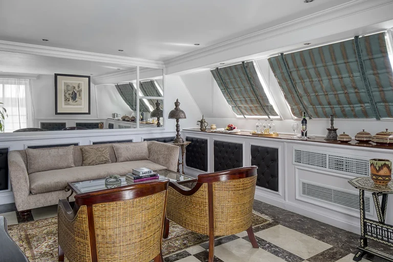 Lounge with sofa, rattan armchairs and slanted windows