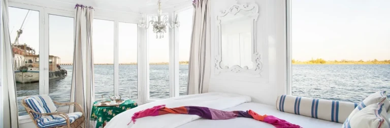 Cabin bed with chandelier and windows on the Nile