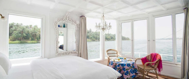 Bright cabin with bed, chandelier and wicker chairs