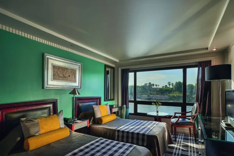 Twin cabin with green wall and palm-view window on the Sun Ray