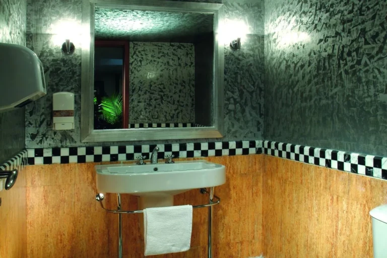 Washbasin and mirror with checkered tile trim on the Sun Ray