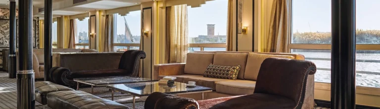 Lounge seating by large river windows on the Movenpick MS Hamees