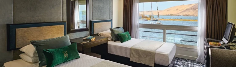 Twin beds with green cushions in a Movenpick MS Hamees cabin