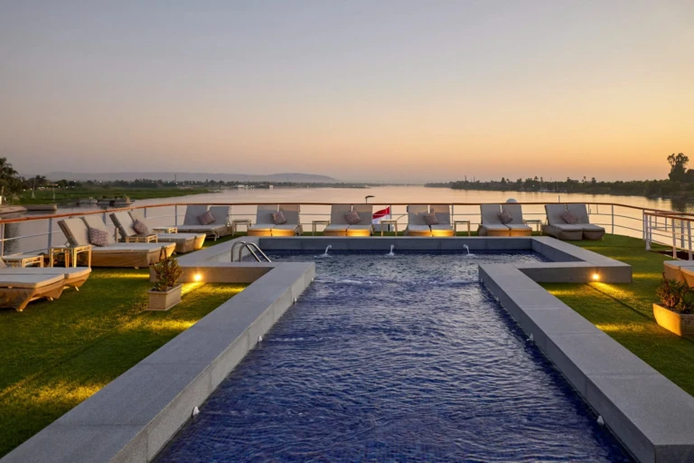 Royal Lily sun deck pool with loungers at dusk