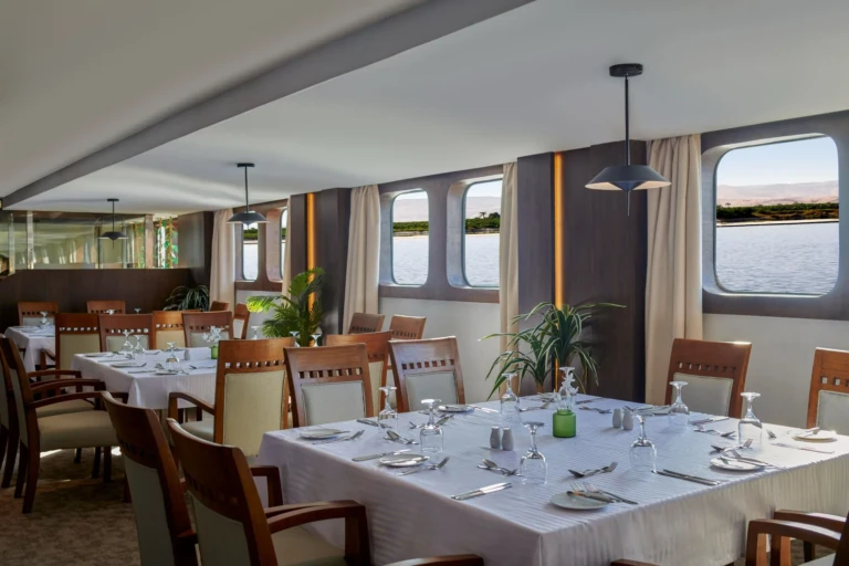 Dining tables set by large windows in the Royal Lily restaurant