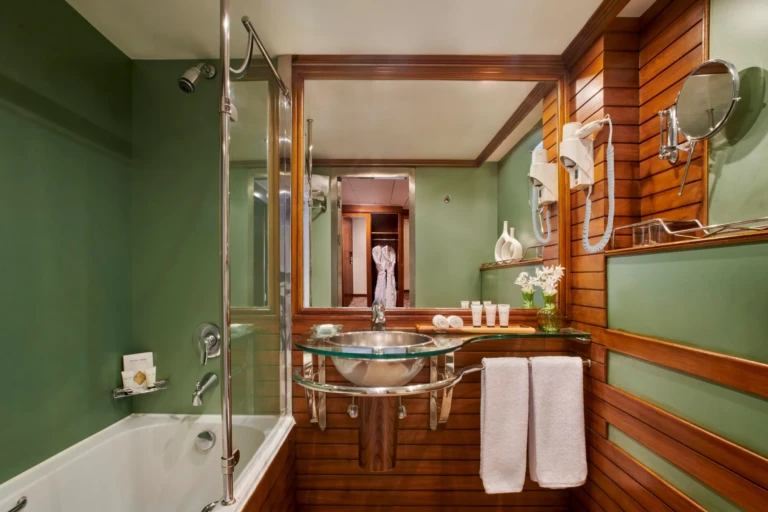 Royal Lotus bathroom with green walls, glass basin and bathtub
