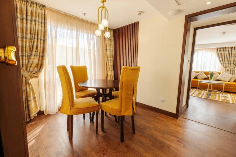 Dining table with mustard chairs in a Nebu suite