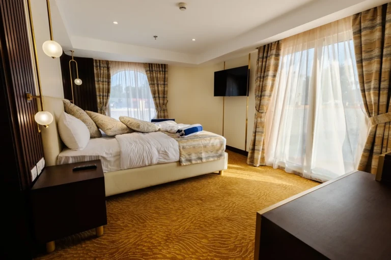 Nebu suite bedroom with double bed, TV and balcony doors