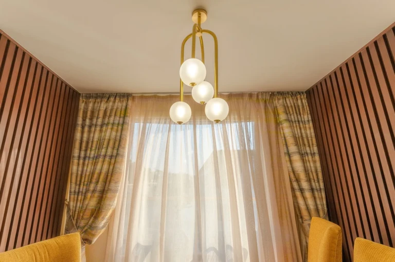 Globe pendant light above a curtained window in a Nebu suite
