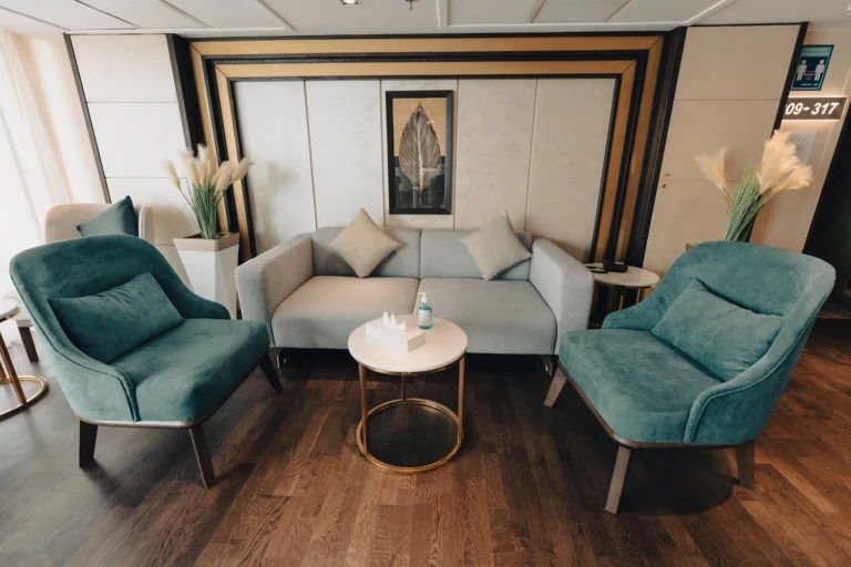 Seating nook with teal armchairs and grey sofa on the Nebu