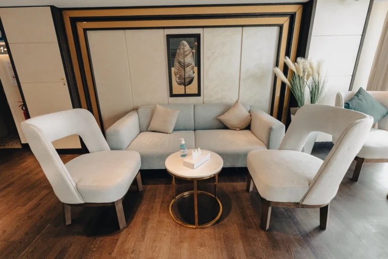 Cream sofa and armchairs around a marble side table on the Nebu