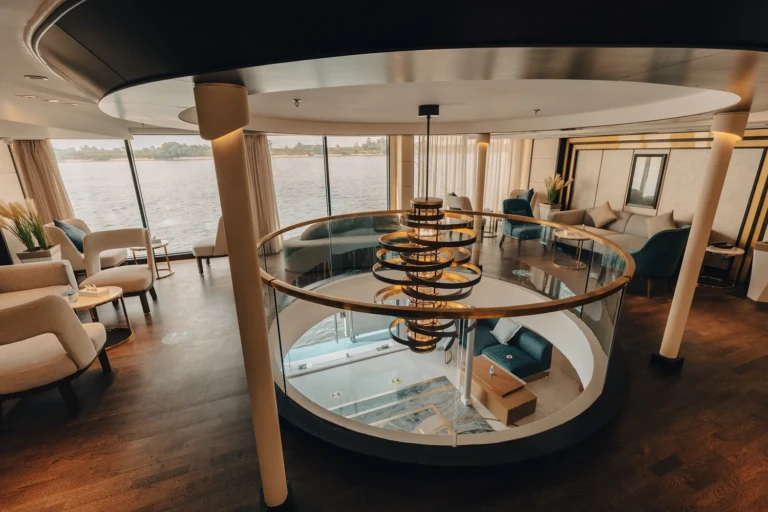 Lounge around a circular glass atrium with chandelier on the Nebu