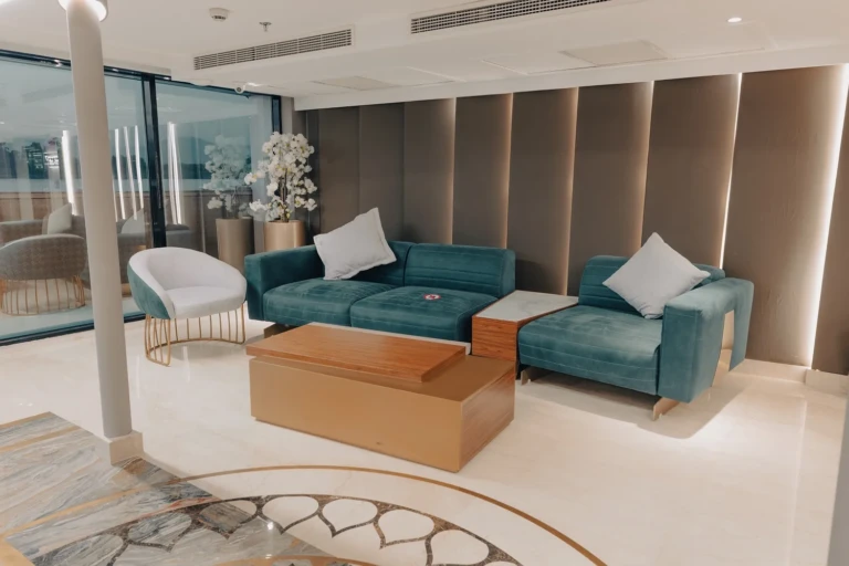 Lobby corner with teal sofa and white armchair on the Nebu