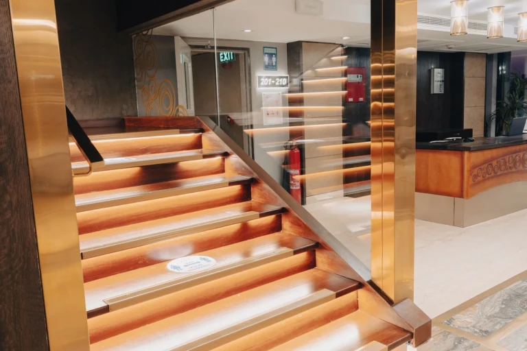 Illuminated staircase with glass balustrade near reception on the Nebu