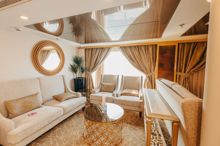 Suite sitting area with sofa, armchairs and round mirror on the Nebu