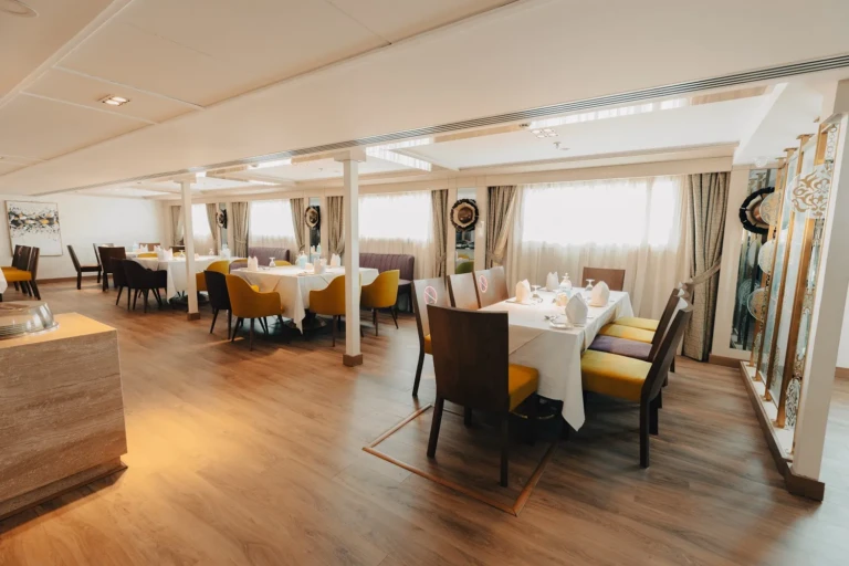 Nebu dining room with white-clothed tables and yellow chairs