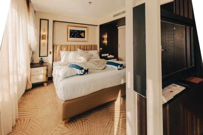Double bed with folded towels and wardrobe in a Nebu cabin