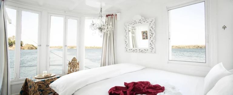 White cabin with chandelier and Nile windows on the Nour El Nil