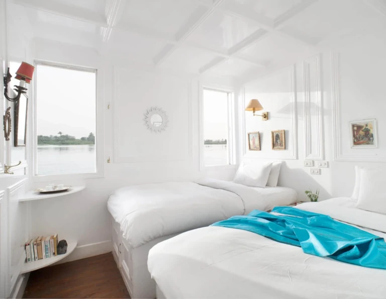 Twin beds in a white cabin on the Nour El Nil dahabiya