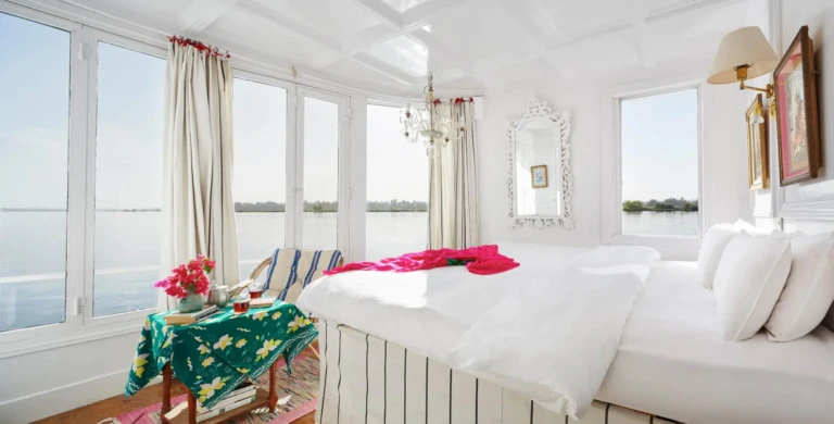 Nour El Nil cabin with wide windows and red throw on the bed