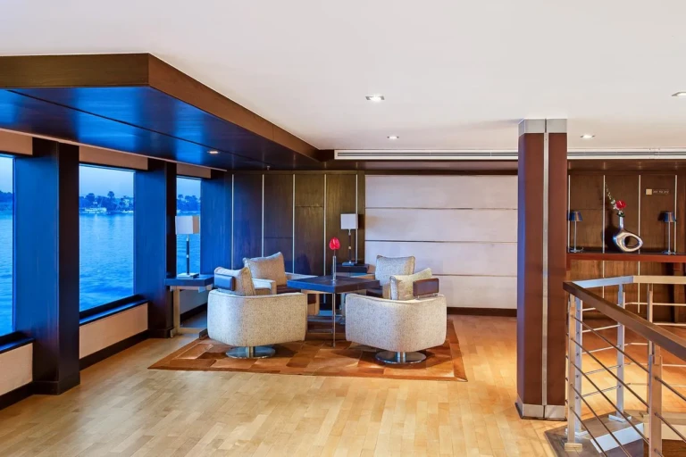 Seating corner with white armchairs by windows on the Oberoi Zahra