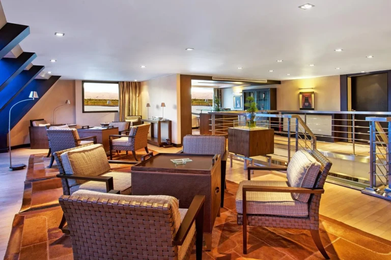 Lounge with wicker armchairs and staircase on the Oberoi Zahra