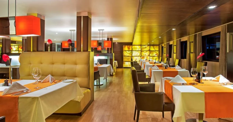 Restaurant booths with orange table runners on the Oberoi Zahra