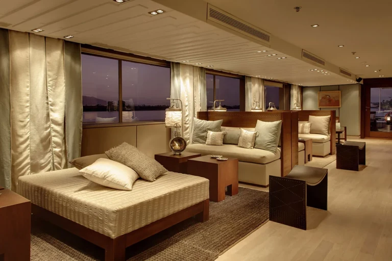 Lounge daybed and sofas by large windows at dusk
