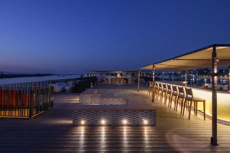 Soleil sun deck bar with stools lit at dusk