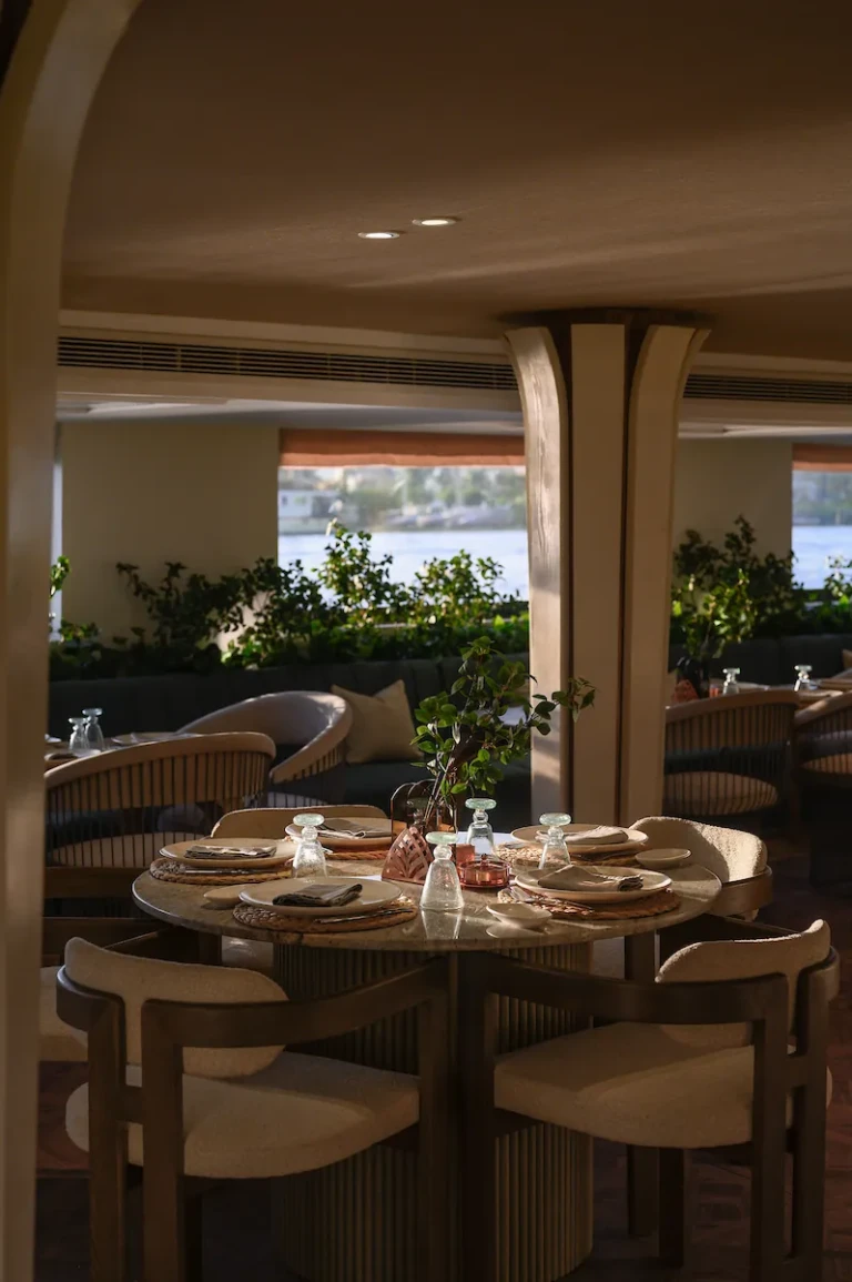 Soleil restaurant round table set beside a planted window