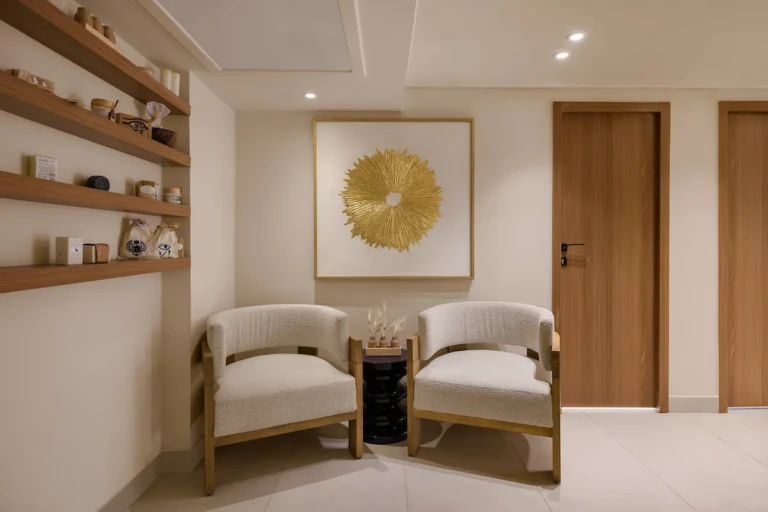 Spa waiting area with two armchairs and gold wall art on the Soleil