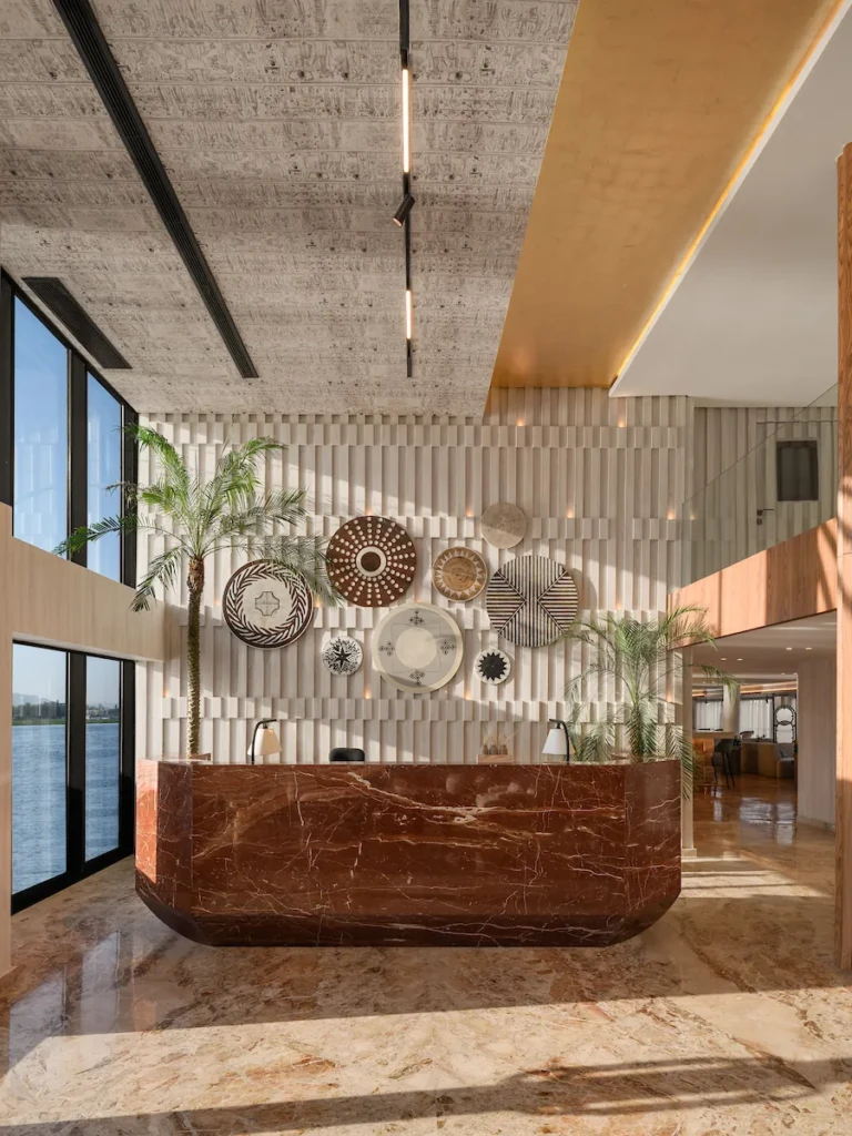 Soleil reception desk in red marble below woven wall plates