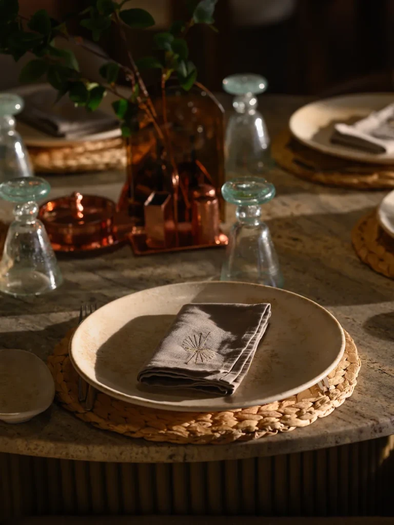 Close-up of a place setting with woven charger on the Soleil