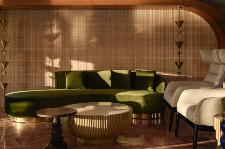 Curved green velvet sofa and round coffee table on the Soleil