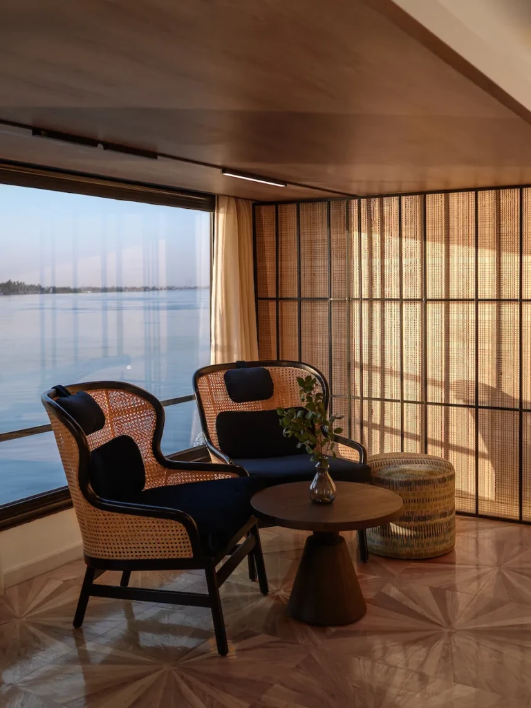 Two rattan armchairs by a Nile view window on the Soleil