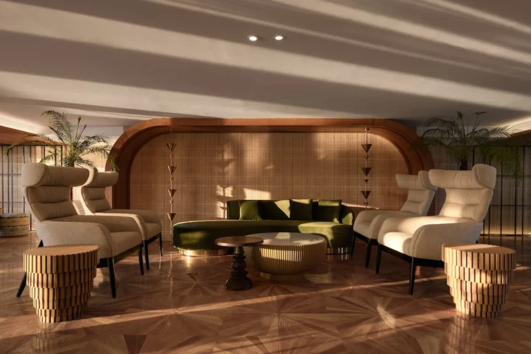 Soleil lounge with green velvet sofa and cream wingback armchairs