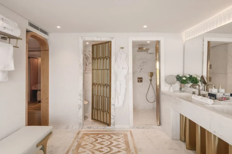 Soleil bathroom with marble floor, shower and toilet cubicles