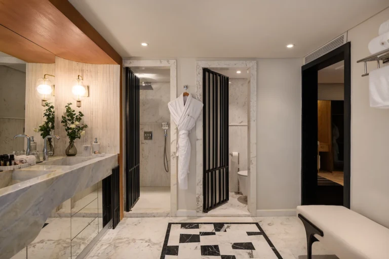 Soleil marble bathroom with vanity, shower and hanging bathrobe
