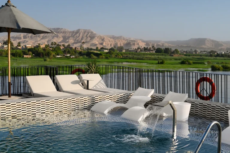 Soleil pool with in-water loungers and desert hills beyond