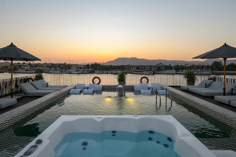 Soleil jacuzzi and pool with sunbeds at sunset