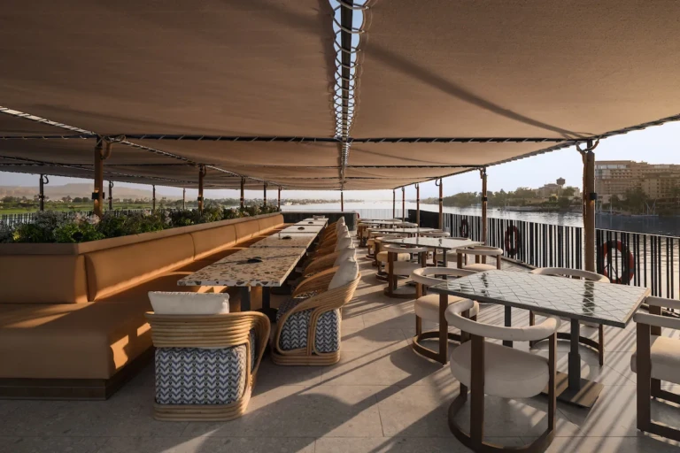 Shaded deck restaurant with tables and banquette seating on the Soleil