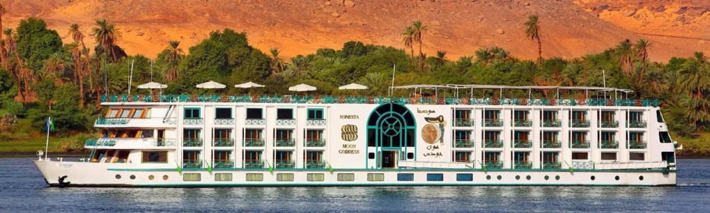 Sonesta Moon Goddess Nile cruise ship by a palm-lined bank