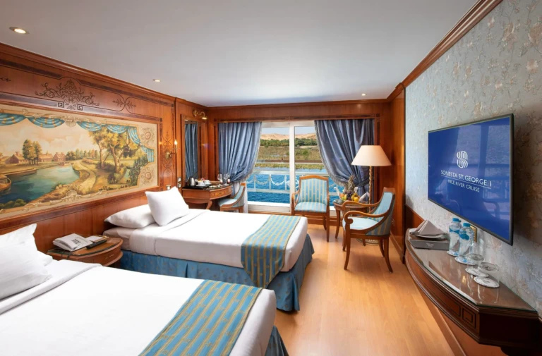 Twin cabin with Nile mural, blue armchairs and balcony door
