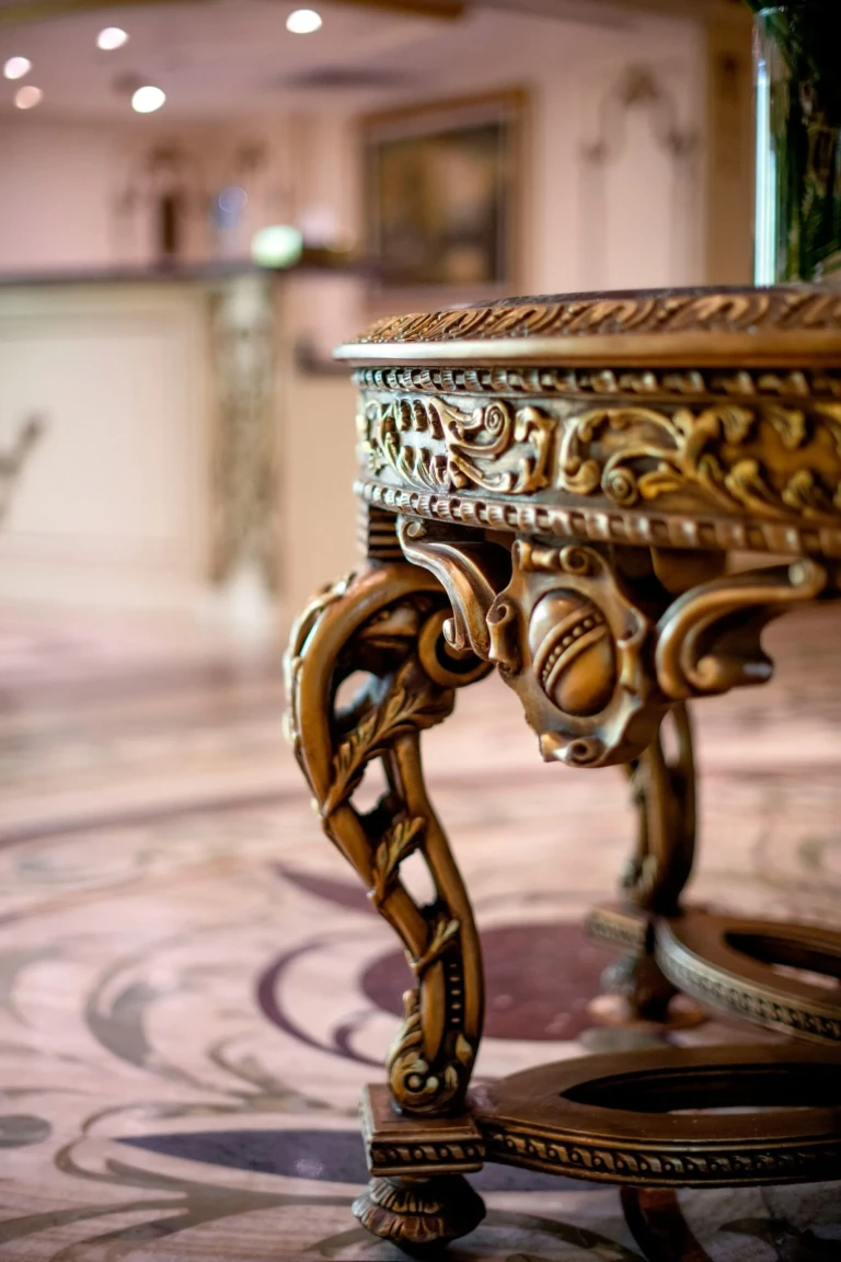 Carved gilded table leg on a mosaic lobby floor